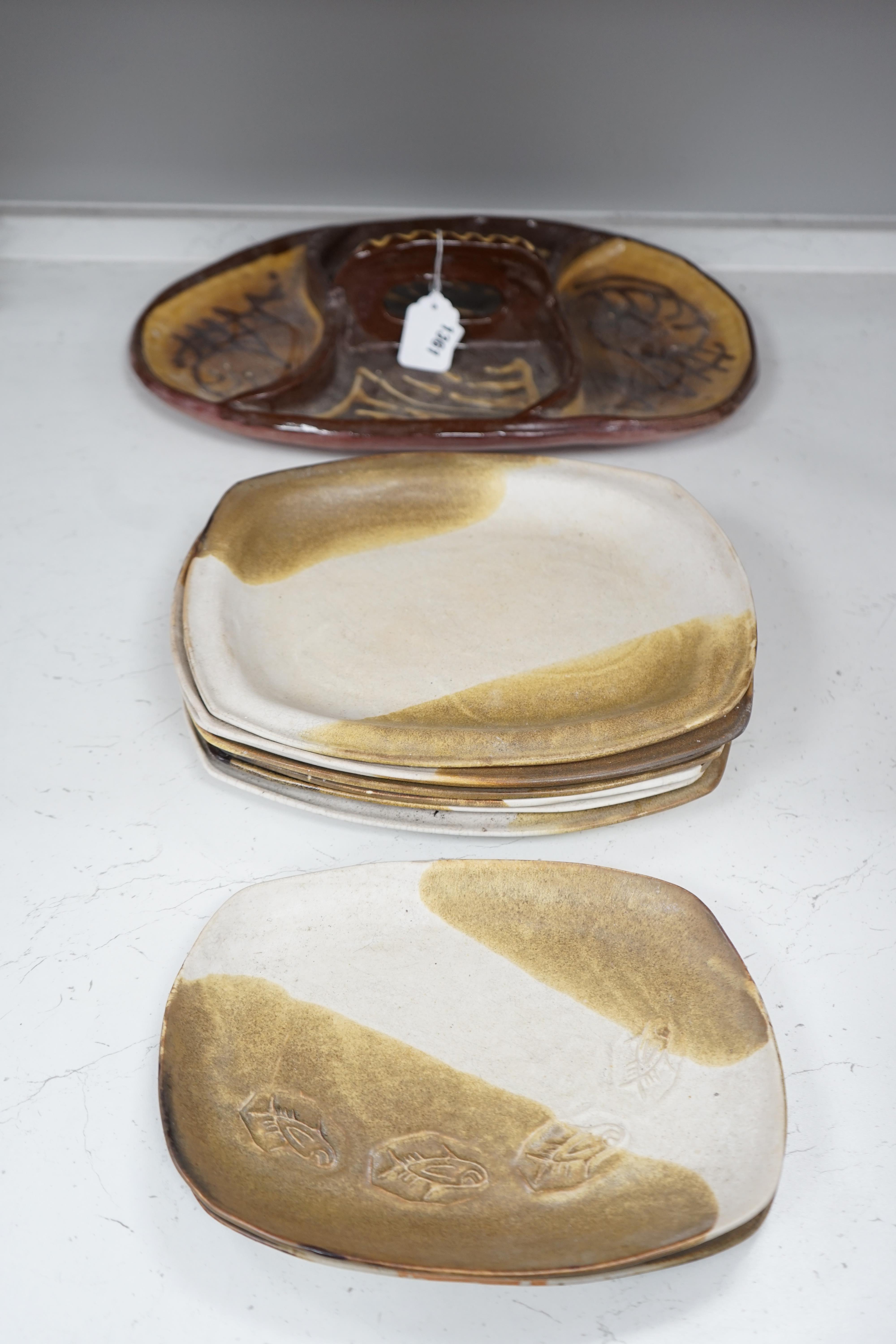 A set of nine studio pottery plates together with a slipware dish, 46cm long